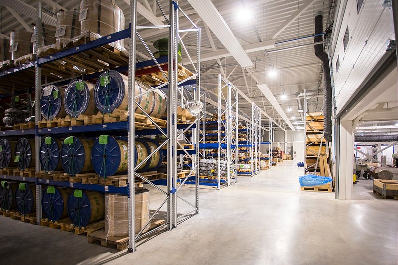 Warehouse racking holding palletised stock, each pallet tagged for identification.